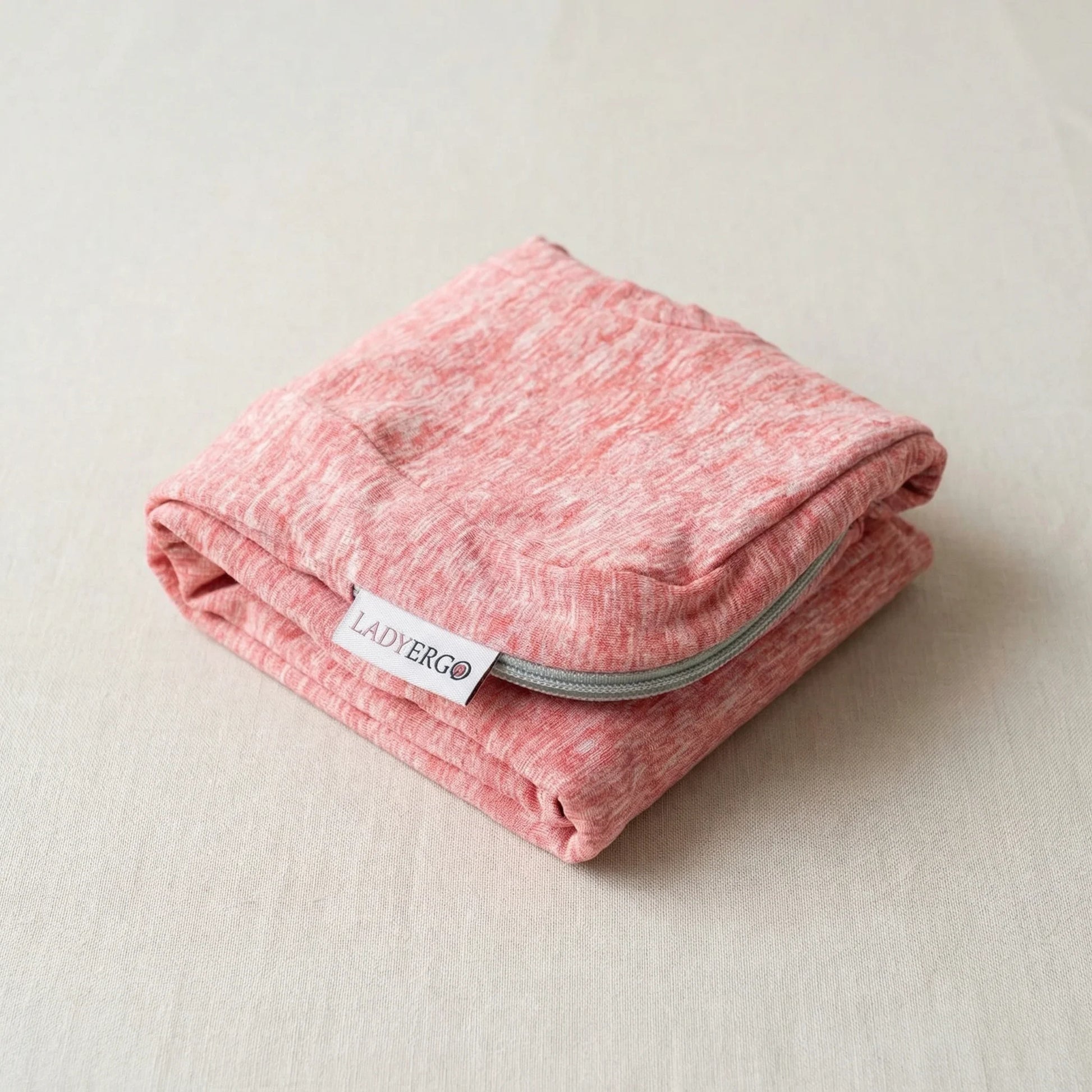 Housse de rechange coussin pour genoux LadyErgo coloris rose poudré, pliée soigneusement avec étiquette visible